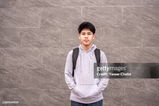 teenager portrait with a grey background - malaiischer herkunft stock-fotos und bilder