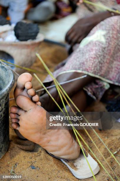 Détail de pieds d'une femme de l'Association Sorkomana, récupérant du plastique pour créer des bracelets et bagues à Djenné le 31 décembre 2008, Mali