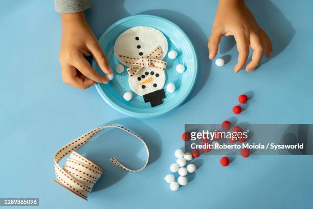 overhead view of child hands creating a snowman toy at christmas - child craft stock pictures, royalty-free photos & images