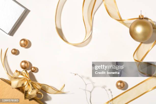 クリスマスの背景。白い背景に分離された金色のリボンとクリスマスの装飾品やギフトボックス - プレゼント　リボン ストックフォトと画像