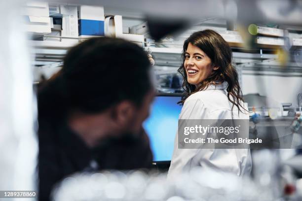 smiling doctor talking to female colleague in hospital - médecin content photos et images de collection