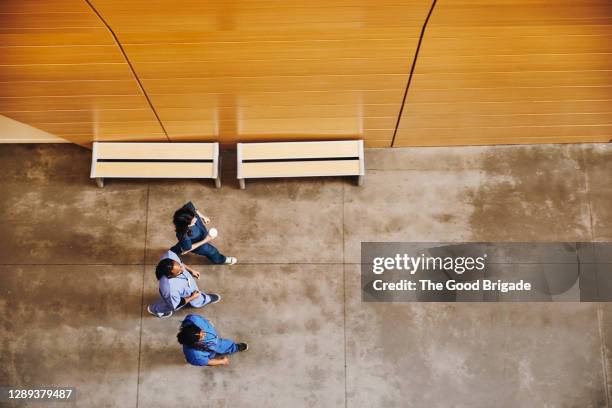 directly above shot of male and female nurses walking down hospital corridor - overhead view walking stock pictures, royalty-free photos & images