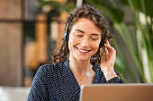 Smiling woman talking to customer on headphones