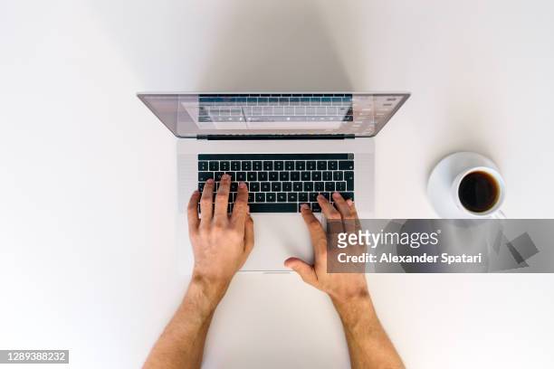 man working on a laptop, directly above view - raised finger stock-fotos und bilder