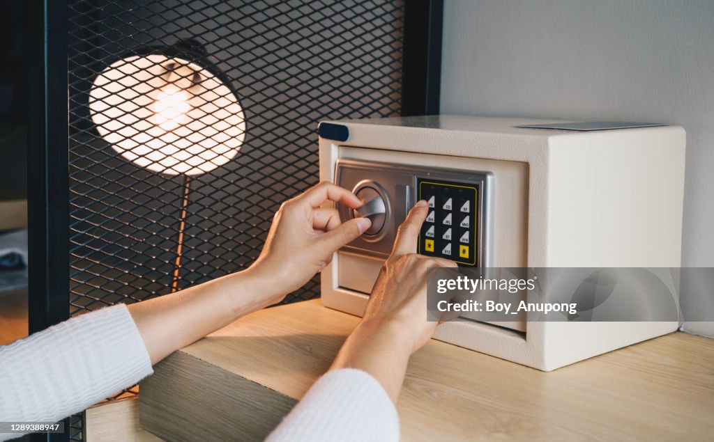 Someone hand trying to press passwords on safety lock pad for open a safety box.