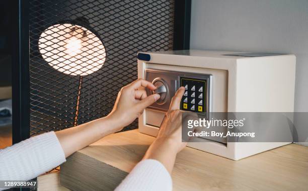 someone hand trying to press passwords on safety lock pad for open a safety box. - caixa de depósito de cofre - fotografias e filmes do acervo
