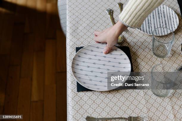 crop woman setting table for dinner - empty plate hands stock pictures, royalty-free photos & images