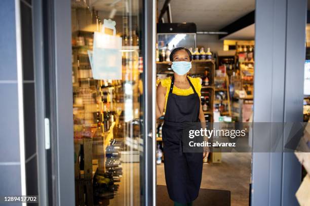 female store owner at doorway during covid-19 - boutique entrance stock pictures, royalty-free photos & images