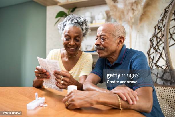 adultos mayores que toman medicamentos en casa - receta documento fotografías e imágenes de stock