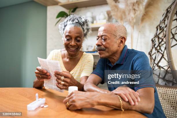 hogere volwassene die medicijn thuis neemt - medicare stockfoto's en -beelden