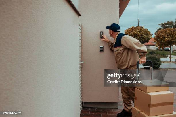 entregador entregando um pacote - ringing doorbell - fotografias e filmes do acervo