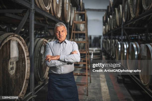 portrait of senior sommelier in cellar. - whisky distillery stock pictures, royalty-free photos & images