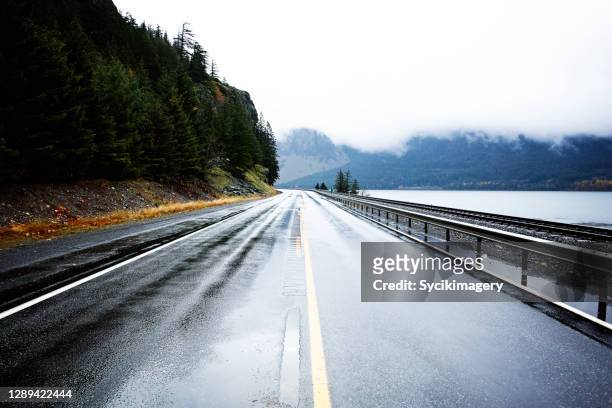 empty wet two lane highway in pacific northwest - two lane highway stock-fotos und bilder