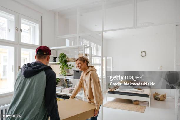 young couple moving into a new apartment - relocation stock pictures, royalty-free photos & images