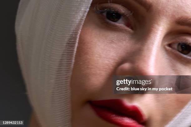 a close-up of a young woman wearing a bandage, slightly blurred with motion - facelift stock-fotos und bilder