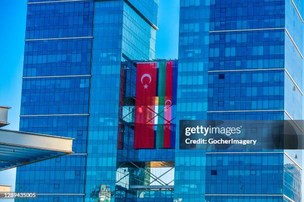 Turkish and Azerbaijani national flags are displayed on the facade of a skyscraper in Sogutozu district, Ankara, Turkey. Turkey shows its full...