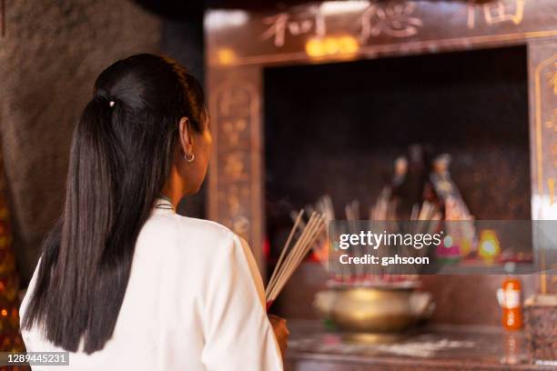 mujer rezando en el templo con palos de incienso - prayer pose greeting fotografías e imágenes de stock