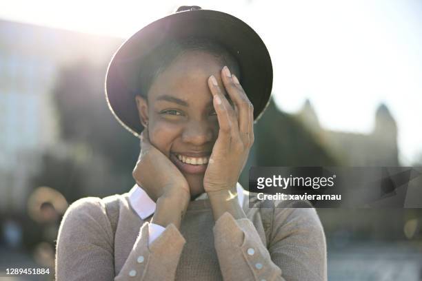 portret van verlegen zwarte vrouw die de vreugde op haar gezicht bewaakt - humility stockfoto's en -beelden