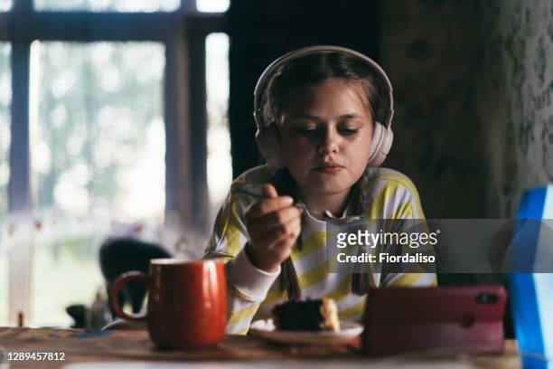 girl 
in headphones using mobile phone - chubby teenager ストックフォトと画像