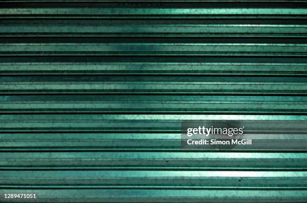 closed metallic green metal roller shutter - roller shutter stock pictures, royalty-free photos & images