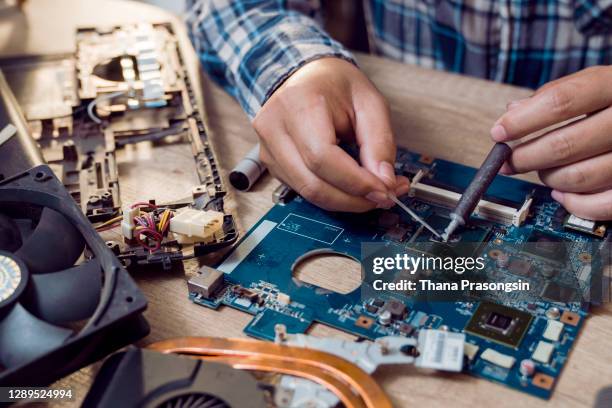 close up of a man soldering computer chip - electronics industry fotografías e imágenes de stock