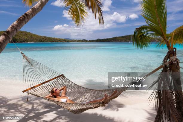 femme détendant dans un hamac sur une plage tropicale - lagon photos et images de collection