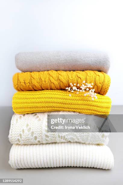 stack of trend yellow orange woolen knitted sweaters close-up, texture, background. - folded clothes stock pictures, royalty-free photos & images