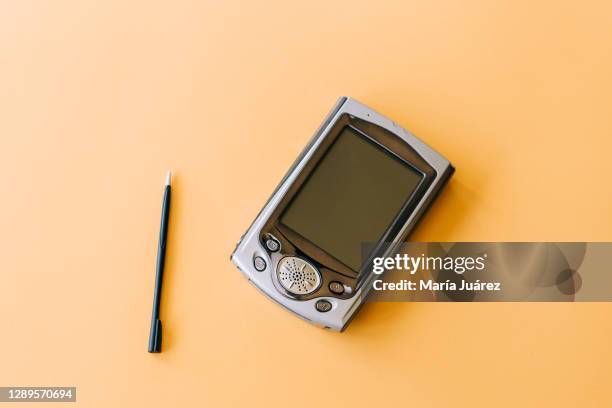 old style pda smartphone on yellow background - 2000s style 個照片及圖片檔