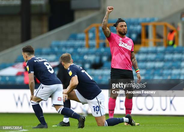 Colin Kazim-Richards of Derby County raises his right fist as other players take the knee ahead of the Sky Bet Championship match between Millwall...