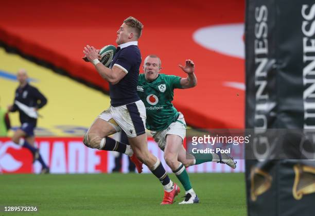 Duhan van der Merwe of Scotland runs in to score their first try chased by Keith Earls of Ireland during the Autumn Nations Cup match between Ireland...