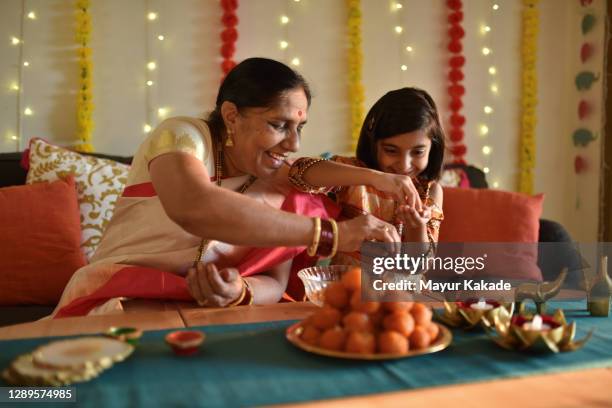 girl helping grandmother in kitchen - india diwali lights stockfoto's en -beelden