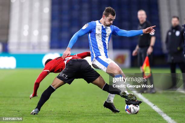 Harry Toffolo of Huddersfield Town is challenged by Chris Willock of Queens Park Rangers during the Sky Bet Championship match between Huddersfield...