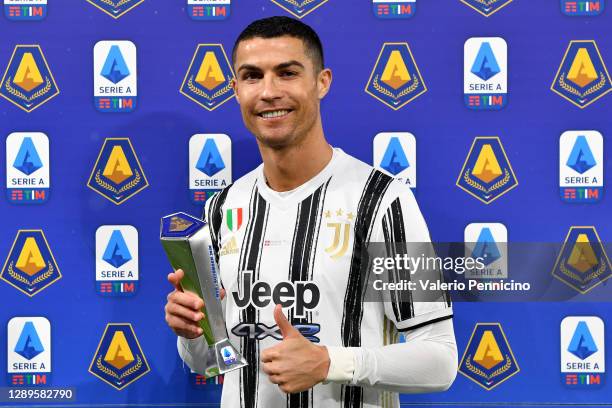 Cristiano Ronaldo of Juventus poses for a picture with his November 2020 MVP trophy prior to the Serie A match between Juventus and Torino FC at...