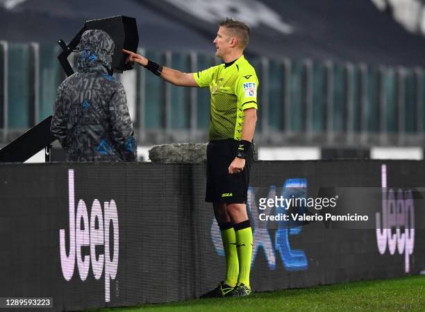 Referee Daniele Orsato checks the pitchside monitor during a VAR review before disallowing the goal scored by Juan Cuadrado of Juventus F.C. For...