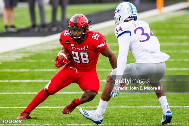 Running back Tahj Brooks of the Texas Tech Red Raiders runs the ball against safety Nate Betts of the Kansas Jayhawks during the first half of the...