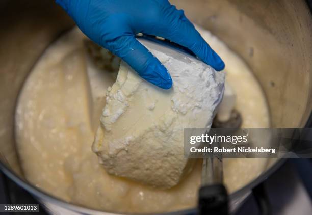 Artist Addison Walz mixes shea butter into a metal pot to make cold-process bar soap at her company's studio, Mater Soap, on September 29, 2020 in...