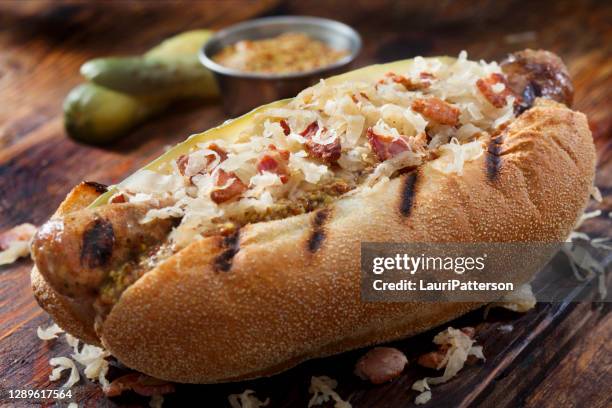 grilled bratwurst with fried sauerkraut and crispy bacon - bratwurst stock pictures, royalty-free photos & images