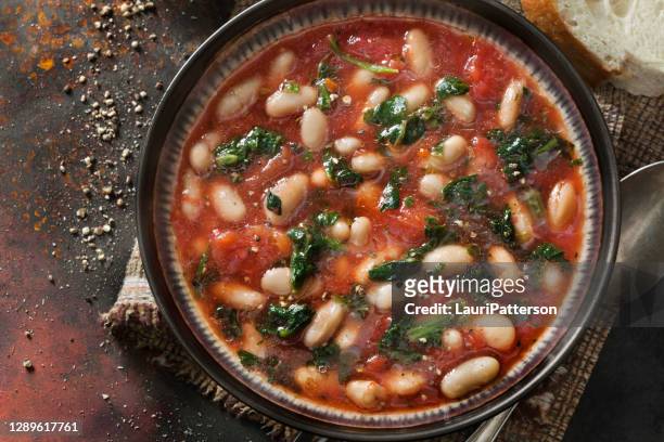 italienische weiße bohne, tortellinisuppe mit spinat und karotten in einer tomatenbrühe - bean stock-fotos und bilder