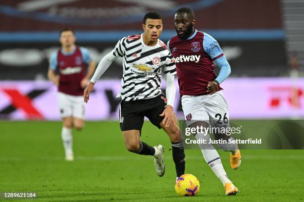 Arthur Masuaku of West Ham United holds off Mason Greenwood of Manchester United during the Premier League match between West Ham United and...