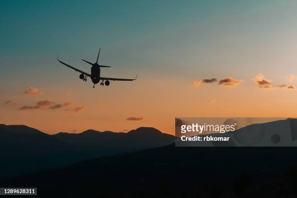 silhouette of an airplane flying over the mountain range at night. emergency landing at a remote location or a lost cargo plane - accident et crash aérien photos et images de collection