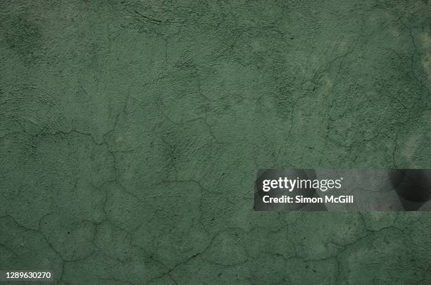 cracked and rough stucco wall painted drag green - khaki green stock-fotos und bilder