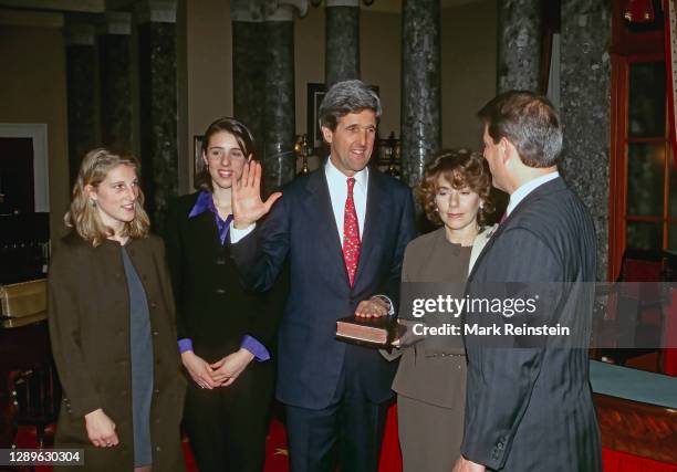 Senator John Forbes Kerry Democrat from Massachusetts with his right hand raised is administered the oath of office by Vice President Albert Gore Jr....