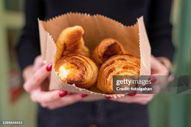 schöne kleine lecker croissants in den händen von mädchen stock foto - croissant stock-fotos und bilder