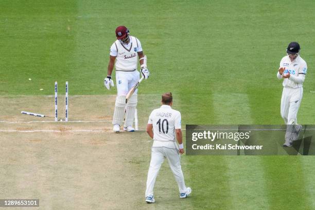 Shannon Gabriel of the West Indies looks dejected after being dismissed by Neil Wagner of New Zealand, who is congratulated by Will Young of New...