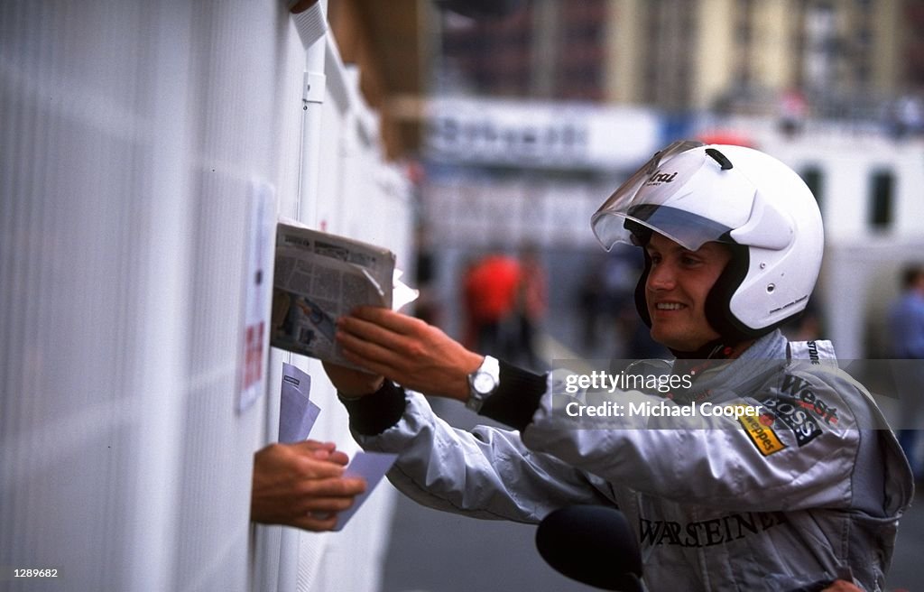 David Coulthard of Scotland and McLaren-Mercedes signs his autograph for the crowds