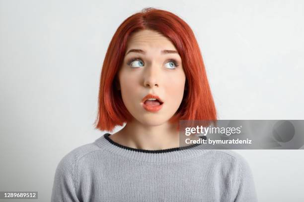 young woman looking away with thoughtful facial expression - asking face stock pictures, royalty-free photos & images