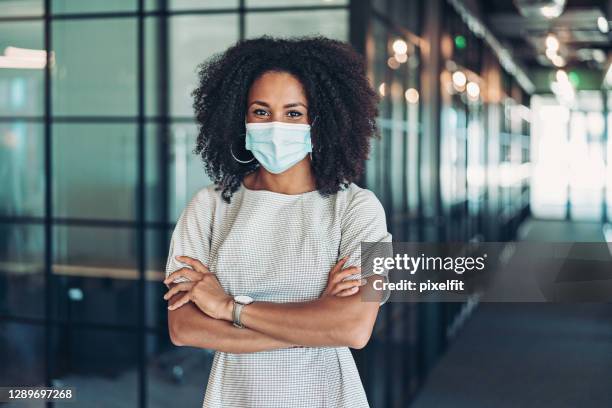 businesswoman with face mask standing in the office - businesswoman mask stock pictures, royalty-free photos & images