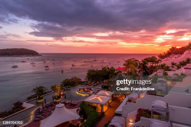 wunderschöner sonnenuntergang am strand von nai harn. touristen auf phuket insel, thailand, indischer ozean - phuket stock-fotos und bilder