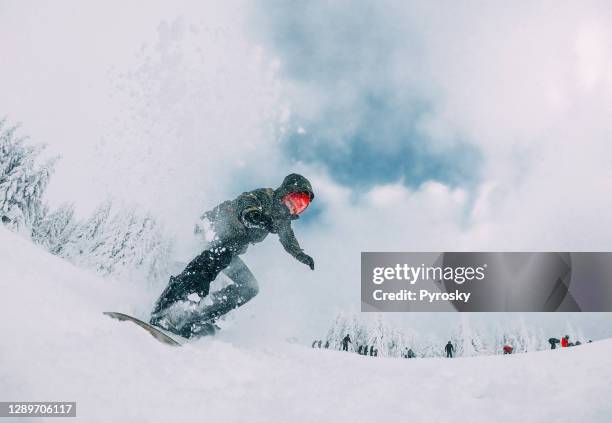 snowboarder springt mit schneestaub - ski slalom stock-fotos und bilder