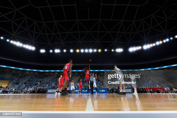 basketball players playing on court - stadium light stock pictures, royalty-free photos & images